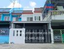 Front view of a modern two-storey townhouse with a gated entrance