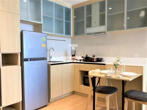 Modern kitchen with large refrigerator and glass cabinets