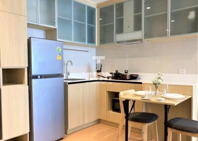Modern kitchen with large refrigerator and glass cabinets
