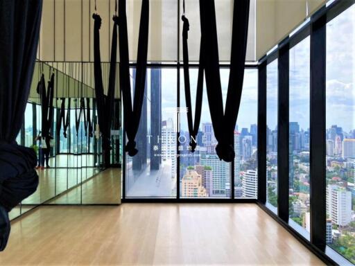 Modern fitness room with large windows overlooking the city skyline