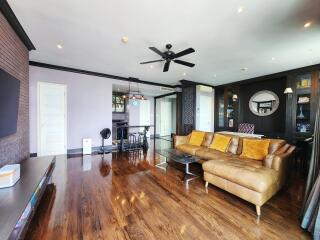 Spacious living room with leather sofa and hardwood floors