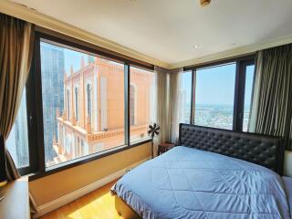 Spacious bedroom with large windows offering city views