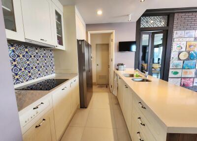 Spacious modern kitchen with decorative tiles and stainless steel appliances