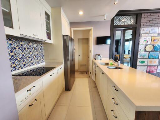 Spacious modern kitchen with decorative tiles and stainless steel appliances