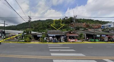 Street view showing local shops and hilly landscape in the background