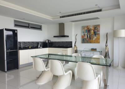 Modern kitchen and dining area with glass table and white chairs