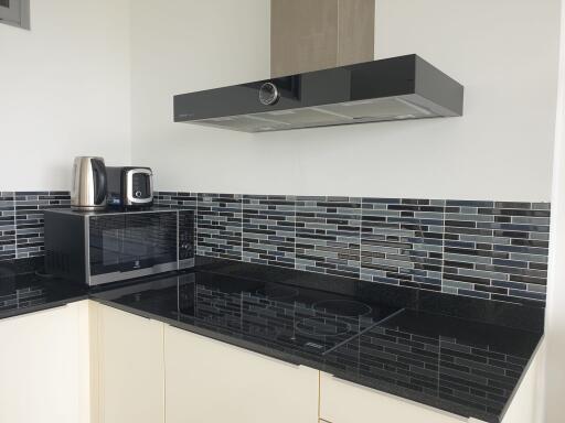 Modern kitchen with black granite countertops and tiled backsplash