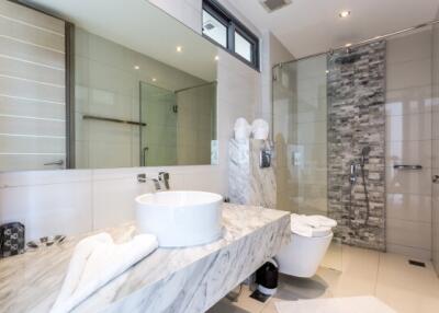Modern bathroom with marble countertops and glass shower