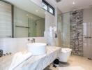 Modern bathroom with marble countertops and glass shower