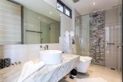 Modern bathroom with marble countertops and glass shower