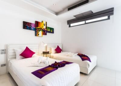Bright and modern twin bedroom with colorful wall art and clean design