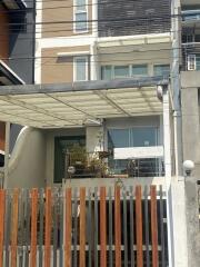 Exterior view of a modern apartment building with visible security fence