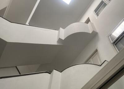Modern white staircase with a skylight and large windows