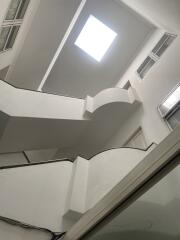 Modern white staircase with a skylight and large windows