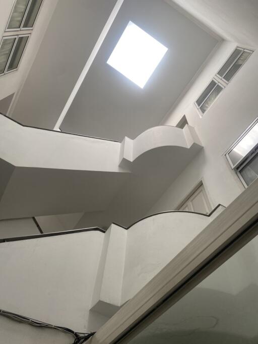 Modern white staircase with a skylight and large windows