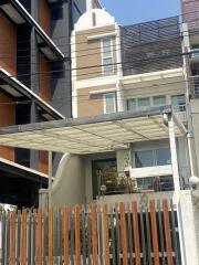 Modern residential building exterior with balcony and privacy fencing