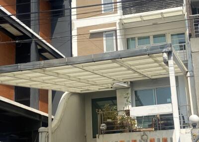 Modern residential building exterior with balcony and privacy fencing