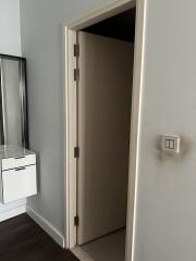 Partial view of a bedroom showing an open door and a modern light switch