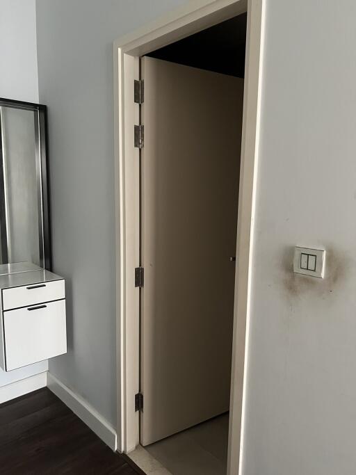 Partial view of a bedroom showing an open door and a modern light switch