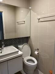 Modern bathroom with reflective mirror and wall-mounted fixtures