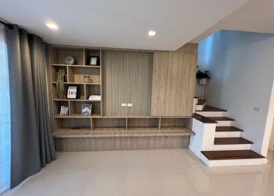 Modern living room with integrated wooden shelving and staircase