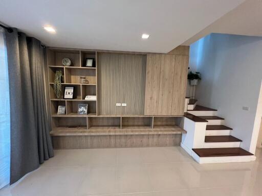 Modern living room with integrated wooden shelving and staircase
