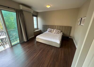 Modern bedroom with balcony access and hardwood floors