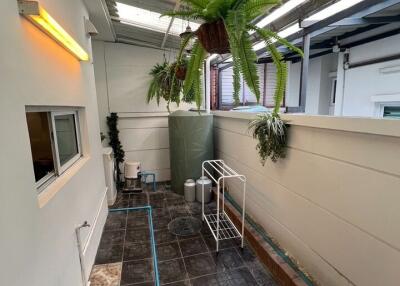 Spacious covered patio with hanging plants and stylish flooring