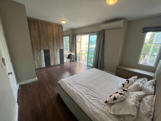 Spacious bedroom with modern design, hardwood flooring, and ample natural light