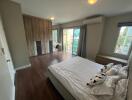 Spacious bedroom with modern design, hardwood flooring, and ample natural light