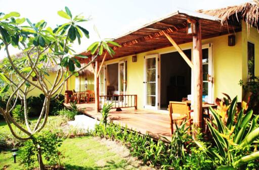 Charming yellow house with tropical garden and wooden deck