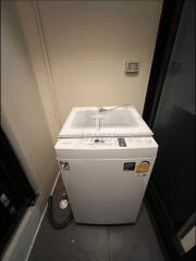 Compact laundry area with modern washing machine