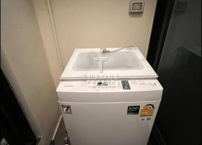 Compact laundry area with modern washing machine