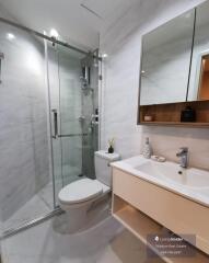 Modern bathroom with glass shower enclosure and wooden vanity
