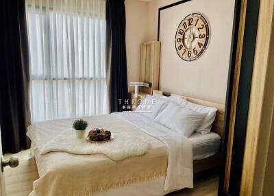 Elegant modern bedroom with large bed and decorative wall clock