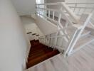 Elegant white staircase with wooden steps in a modern home