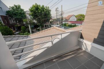 Spacious balcony overlooking a residential area with modern safety railing and ample daylight