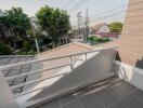 Spacious balcony overlooking a residential area with modern safety railing and ample daylight