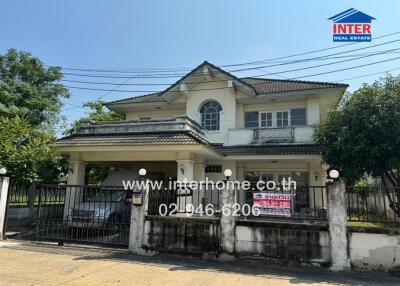 Front view of a two-story residential house with gated entrance