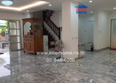 Spacious living room with marble flooring and staircase