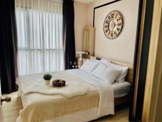 Elegantly furnished bedroom with large bed and stylish wall clock