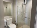 Modern bathroom interior with glass shower enclosure and neutral tones