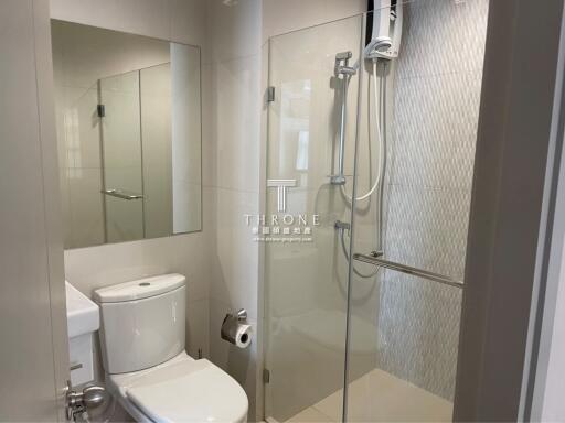 Modern bathroom interior with glass shower enclosure and neutral tones