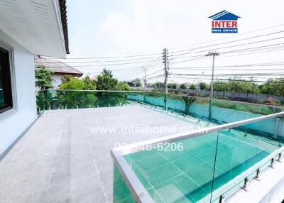 Spacious balcony with glass railing and scenic view