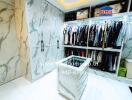 Spacious modern walk-in closet with extensive clothing storage and elegant marble walls