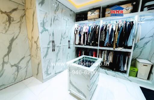 Spacious modern walk-in closet with extensive clothing storage and elegant marble walls