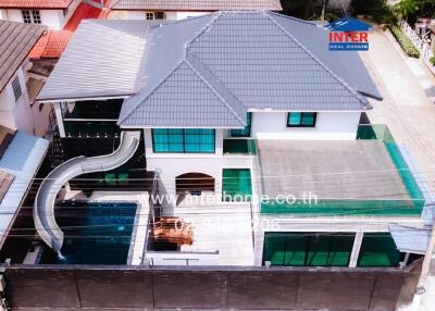Aerial view of a modern house with swimming pool and carport