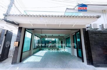 Modern building entrance with glass doors and covered pathway