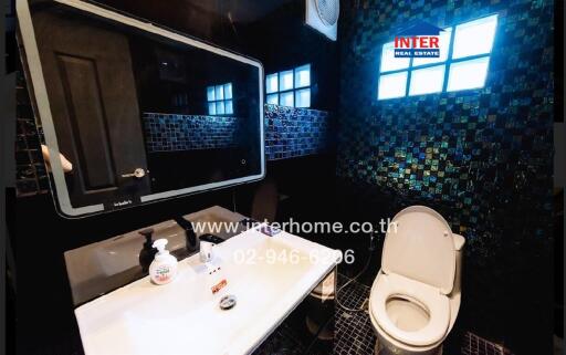 Modern bathroom with black tiled walls and mosaic details