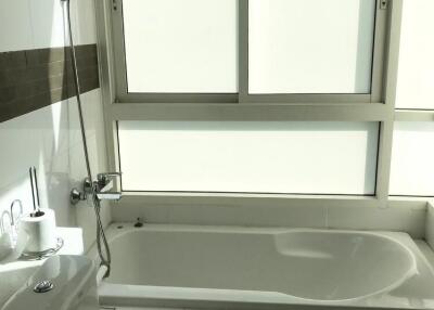 Spacious modern bathroom with large bathtub and bright window